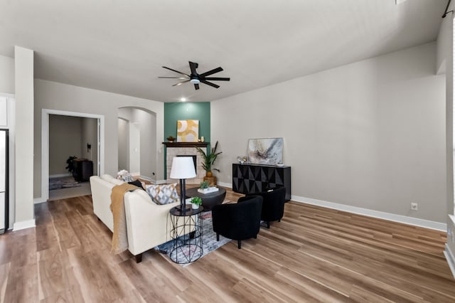 1109 Claiborne Dr, Aubrey, TX 76227 - living area with arched walkways, a ceiling fan, baseboards, and light wood-style floors