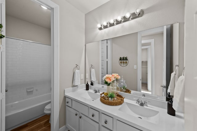 1109 Claiborne Dr, Aubrey, TX 76227 - full bathroom featuring wood finished floors, toilet, double vanity, and a sink