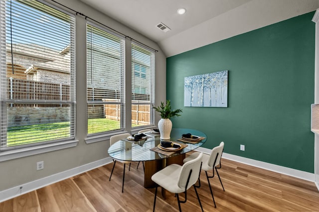 dining room featuring hardwood / wood-style flooring and vaulted ceiling