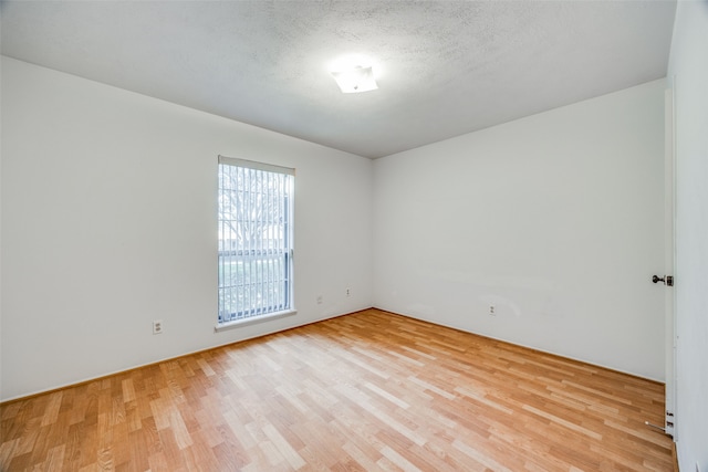 empty room featuring a textured ceiling and light wood-type flooring