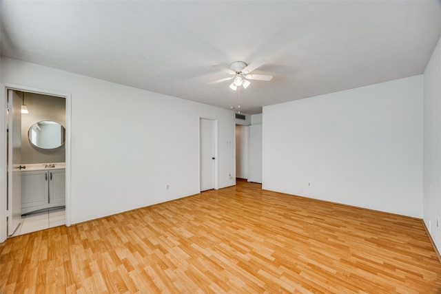 unfurnished bedroom featuring connected bathroom, light hardwood / wood-style floors, and ceiling fan