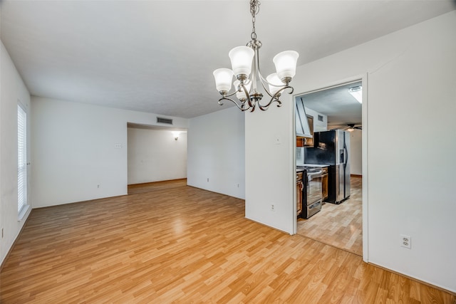 interior space with light hardwood / wood-style flooring and ceiling fan with notable chandelier