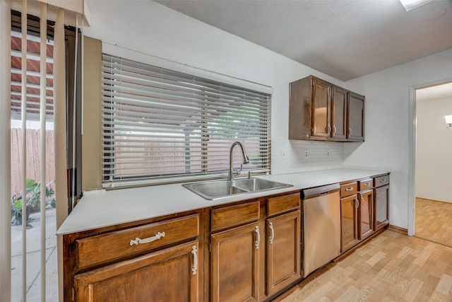 kitchen with sink, light hardwood / wood-style floors, decorative backsplash, and dishwasher