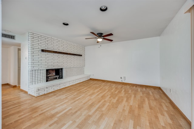 unfurnished living room featuring a fireplace, light wood-type flooring, and ceiling fan