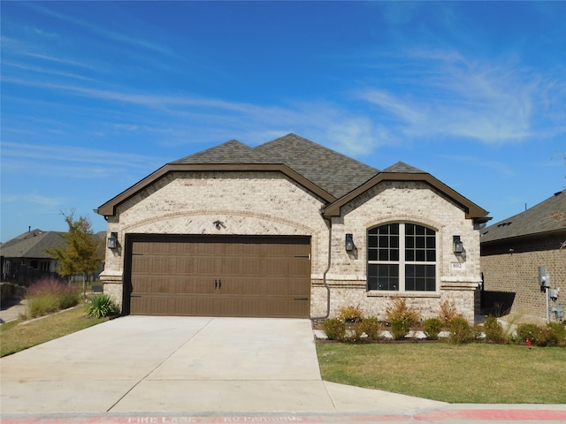 french country home with a front yard and a garage