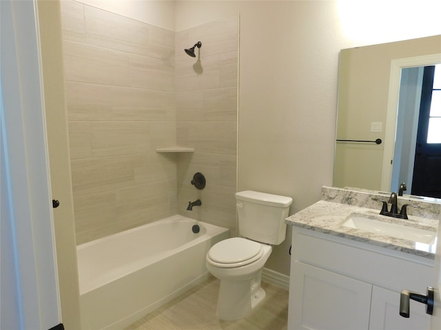 full bathroom featuring tiled shower / bath, vanity, and toilet