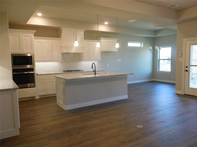 kitchen with an island with sink, dark hardwood / wood-style flooring, white cabinetry, sink, and stainless steel appliances