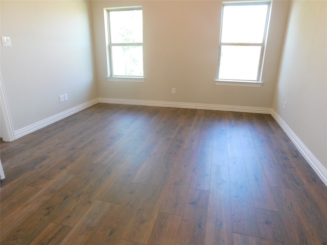 empty room with dark hardwood / wood-style flooring