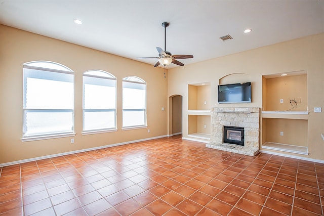 unfurnished living room with tile patterned floors, a wealth of natural light, and built in shelves