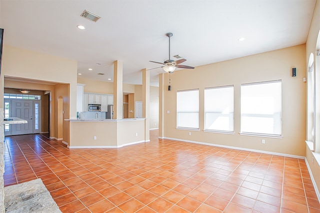 unfurnished living room with light tile patterned flooring and ceiling fan