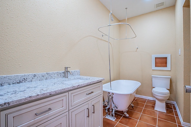 bathroom with toilet, vanity, and tile patterned flooring