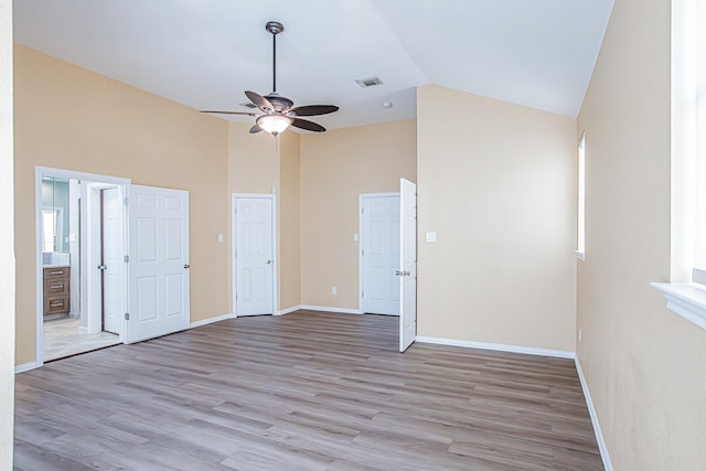 spare room with high vaulted ceiling, light hardwood / wood-style floors, and ceiling fan