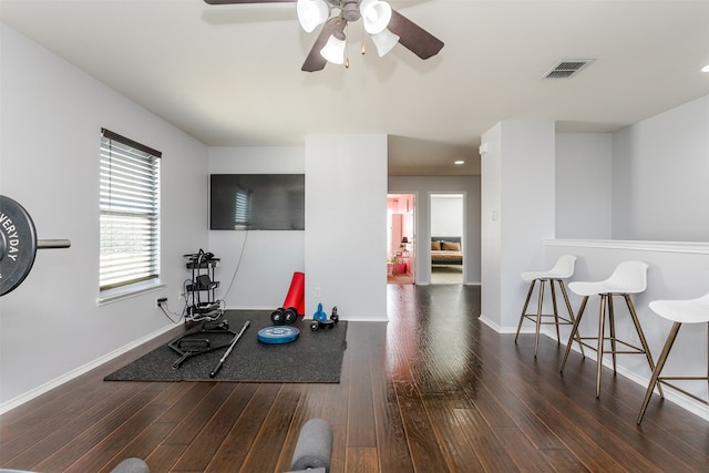 workout area with dark wood-type flooring and ceiling fan