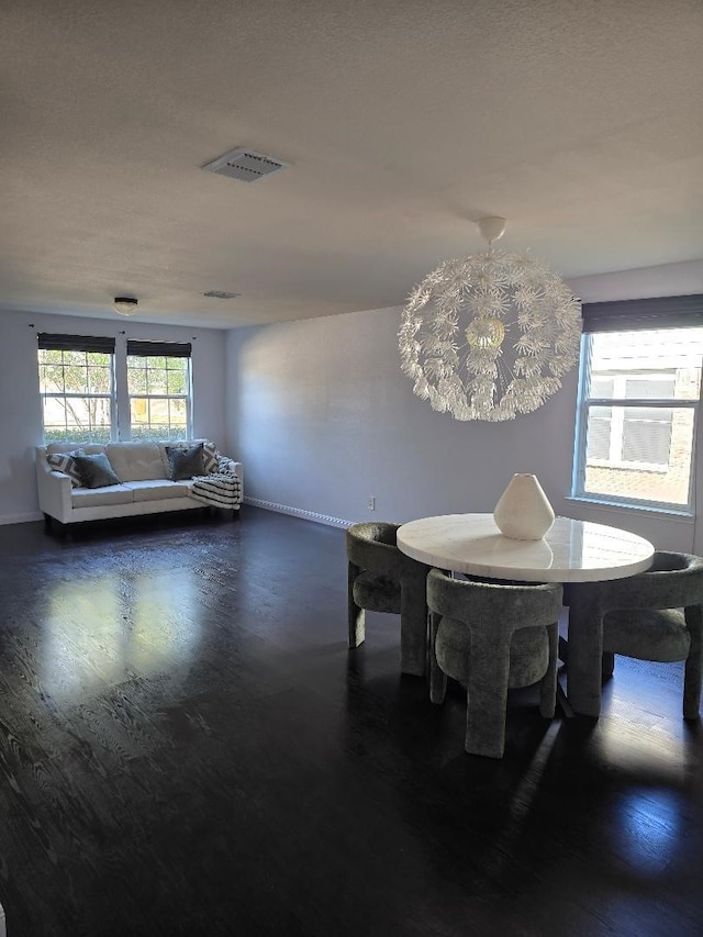 unfurnished dining area featuring dark hardwood / wood-style flooring and an inviting chandelier