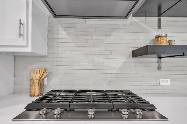 interior details with stainless steel gas cooktop, tasteful backsplash, and white cabinets