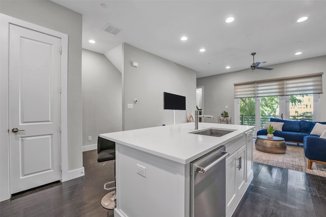 kitchen with dark hardwood / wood-style floors, an island with sink, sink, stainless steel dishwasher, and white cabinets