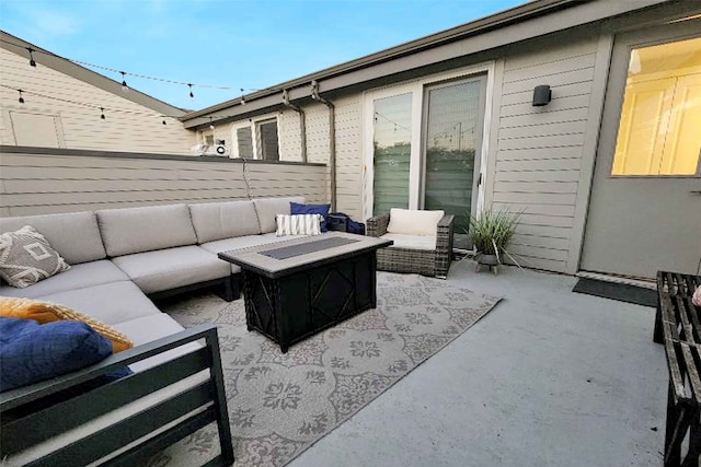 view of patio with an outdoor living space with a fire pit