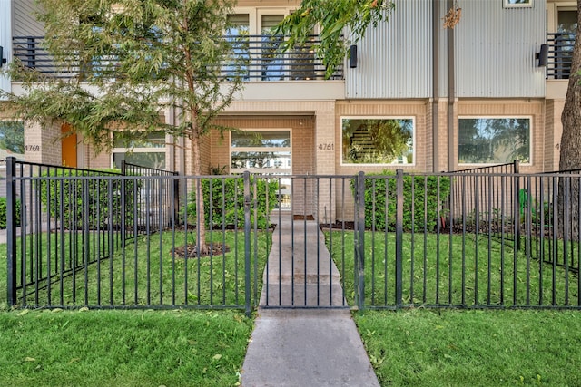 view of front of home featuring a balcony and a front lawn