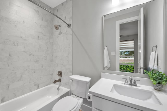 full bathroom featuring vanity, tiled shower / bath combo, and toilet