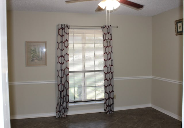 tiled spare room featuring ceiling fan and a textured ceiling