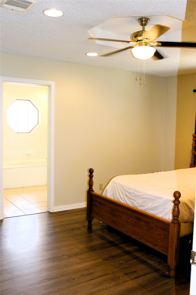 bedroom with ceiling fan, dark hardwood / wood-style floors, and a textured ceiling