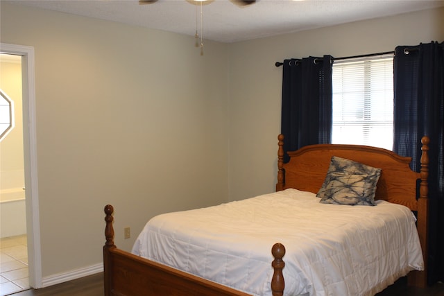 bedroom featuring hardwood / wood-style floors, ensuite bathroom, and ceiling fan