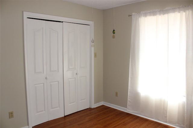 unfurnished bedroom featuring hardwood / wood-style floors and a closet