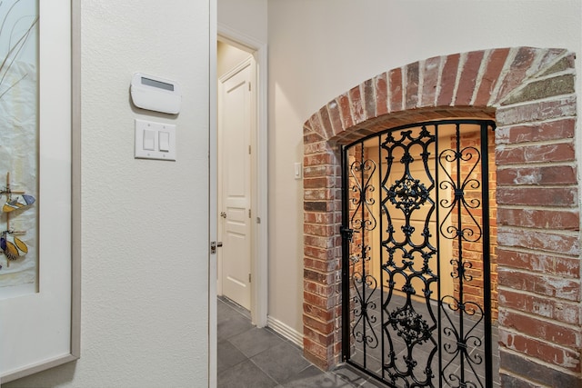 interior space with baseboards and dark tile patterned flooring