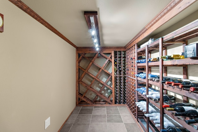 wine room with ornamental molding and tile patterned flooring