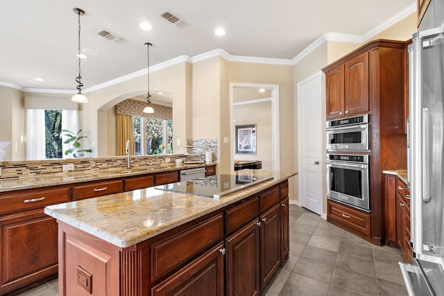 kitchen with a kitchen island, appliances with stainless steel finishes, pendant lighting, tasteful backsplash, and tile patterned flooring