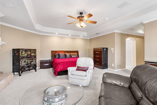 bedroom featuring arched walkways, a raised ceiling, light carpet, and crown molding