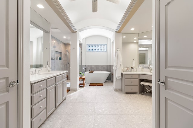 bathroom with tile walls, recessed lighting, a freestanding bath, a stall shower, and vanity