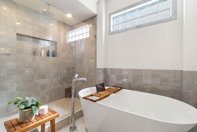 full bathroom featuring a freestanding tub, tile walls, and walk in shower