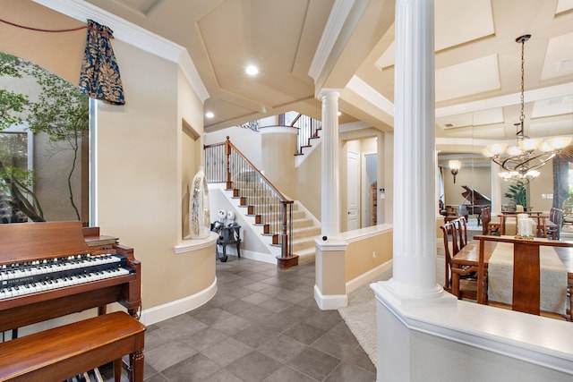 entrance foyer with decorative columns, baseboards, stairway, an inviting chandelier, and crown molding