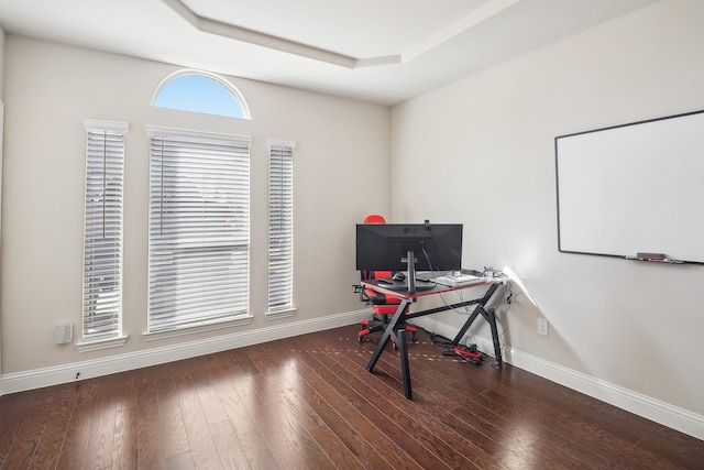 office featuring dark wood-type flooring and a raised ceiling