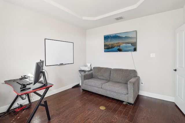 office space with dark hardwood / wood-style floors and a raised ceiling