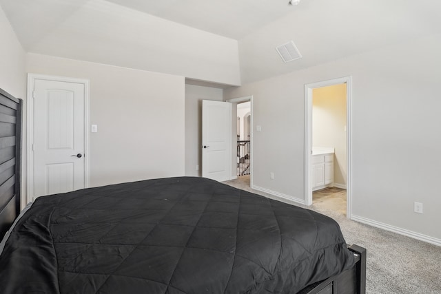 carpeted bedroom featuring vaulted ceiling and ensuite bathroom