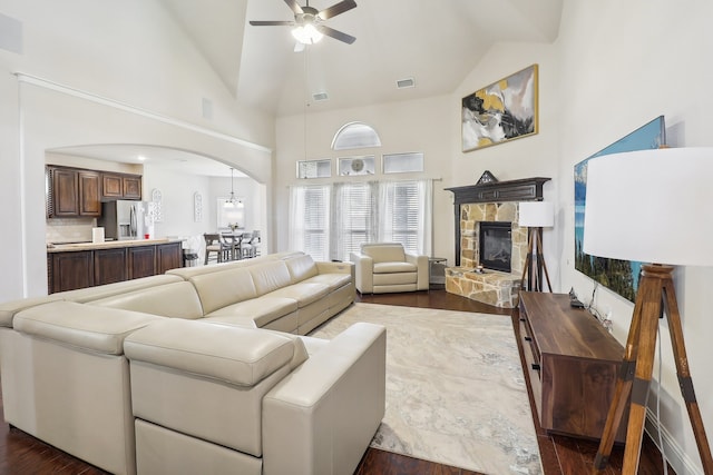 living room with high vaulted ceiling, dark hardwood / wood-style flooring, and a fireplace