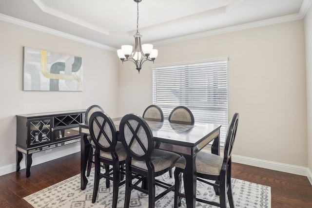 dining room featuring ornamental molding, a notable chandelier, dark hardwood / wood-style floors, and a raised ceiling