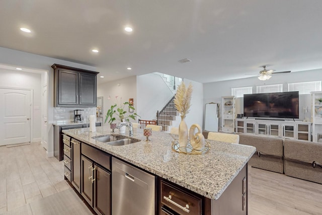 kitchen featuring dishwasher, a center island with sink, sink, ceiling fan, and dark brown cabinetry