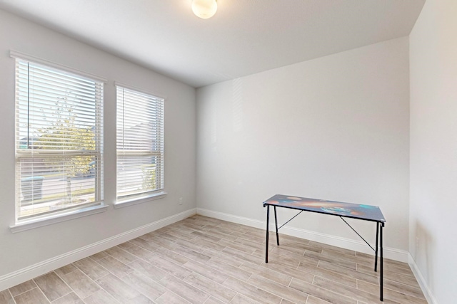 empty room with light hardwood / wood-style floors and a healthy amount of sunlight