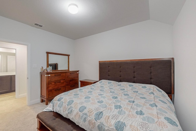 carpeted bedroom featuring ensuite bathroom and vaulted ceiling