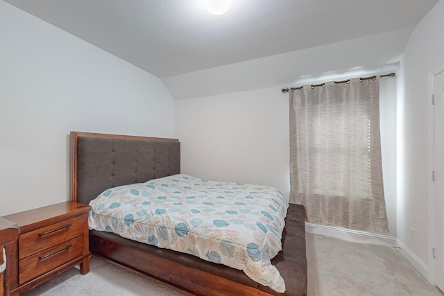 bedroom featuring lofted ceiling and light carpet