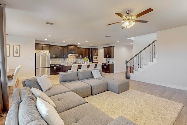 living room featuring light hardwood / wood-style flooring and ceiling fan