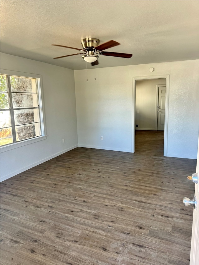 empty room with a textured ceiling, wood-type flooring, and ceiling fan