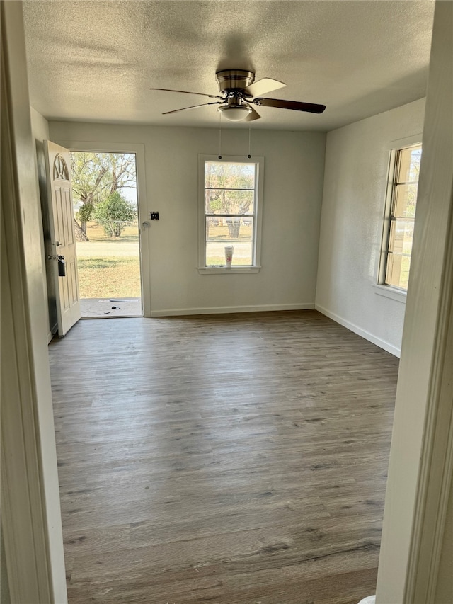 empty room with hardwood / wood-style floors, a textured ceiling, and ceiling fan