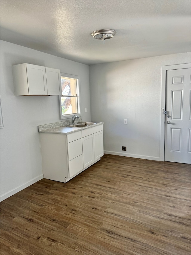 kitchen featuring white cabinets, a textured ceiling, sink, and dark hardwood / wood-style flooring