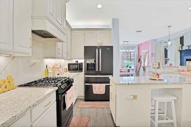 kitchen with pendant lighting, backsplash, light hardwood / wood-style flooring, appliances with stainless steel finishes, and light stone counters