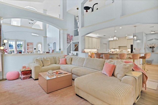 living room with a high ceiling and light hardwood / wood-style flooring