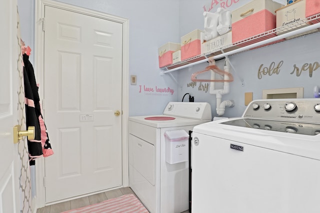 clothes washing area featuring light wood-type flooring and washing machine and clothes dryer